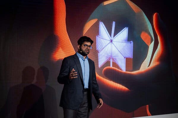 Aravind Srinivas gestures with his right hand while giving a talk. 
