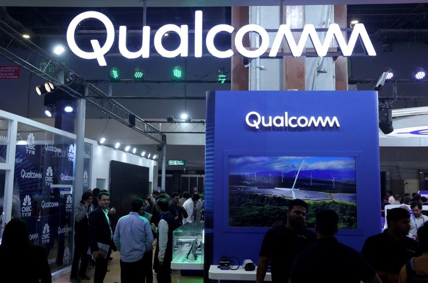 Visitors stand at the Qualcomm kiosk at Bharat Mandapam, one of the venues for AI Impact Summit, in New Delhi, India, February 18, 2026.