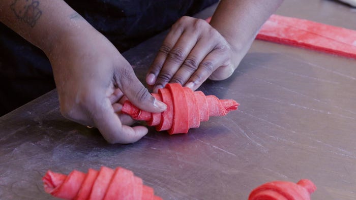 Jatee Kearsley hand rolling a croissant.